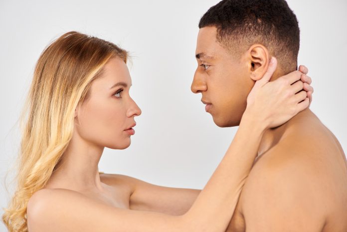 A man and woman tenderly touch each others necks.