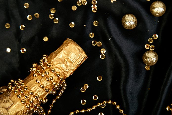 Gold Champagne bottle with confetti stars and party streamers