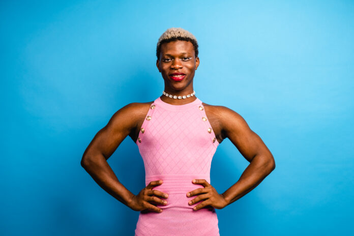 Smiling African transgender person in blue background
